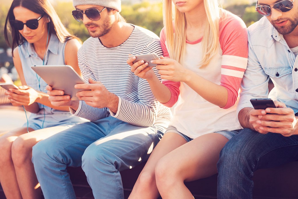 A group of friends on their mobile phones sharing a hotspot